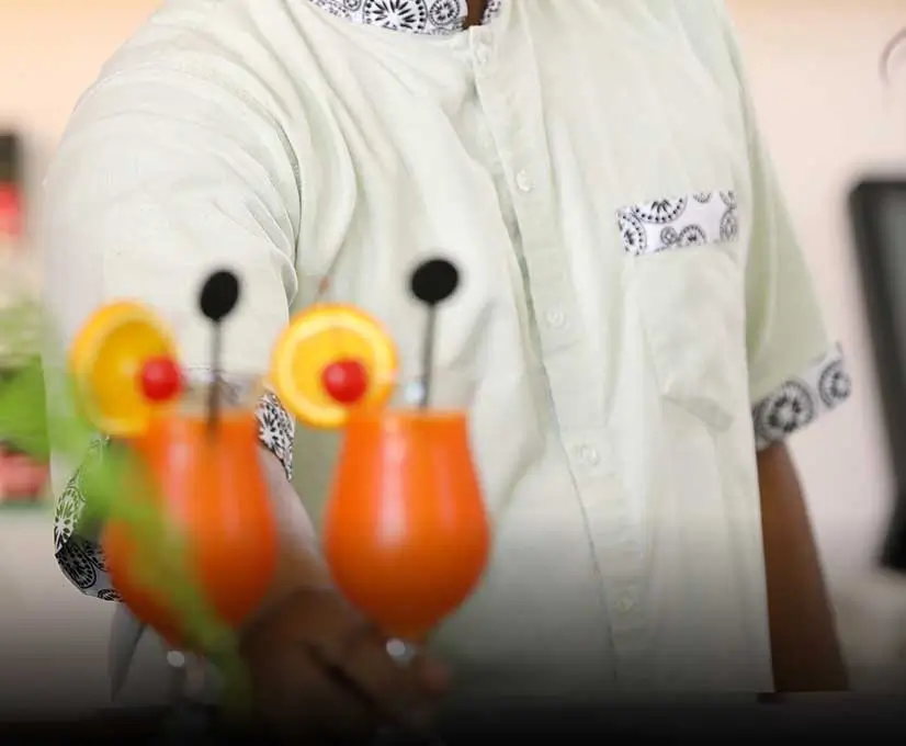 A man in a white shirt holding a cocktail