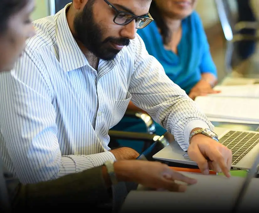 Carson management service employee in glasses is focused on his laptop, working diligently