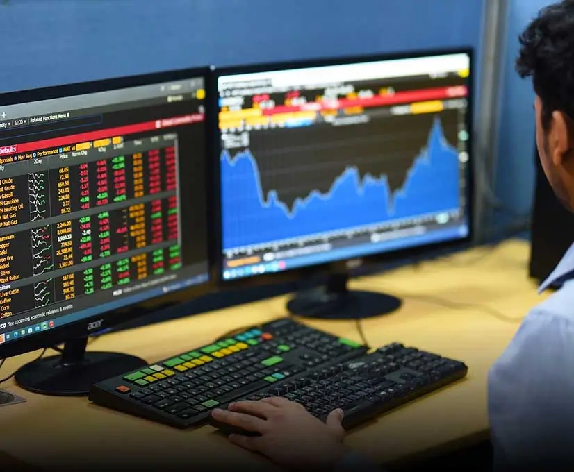 Two computer monitors displaying stock market information